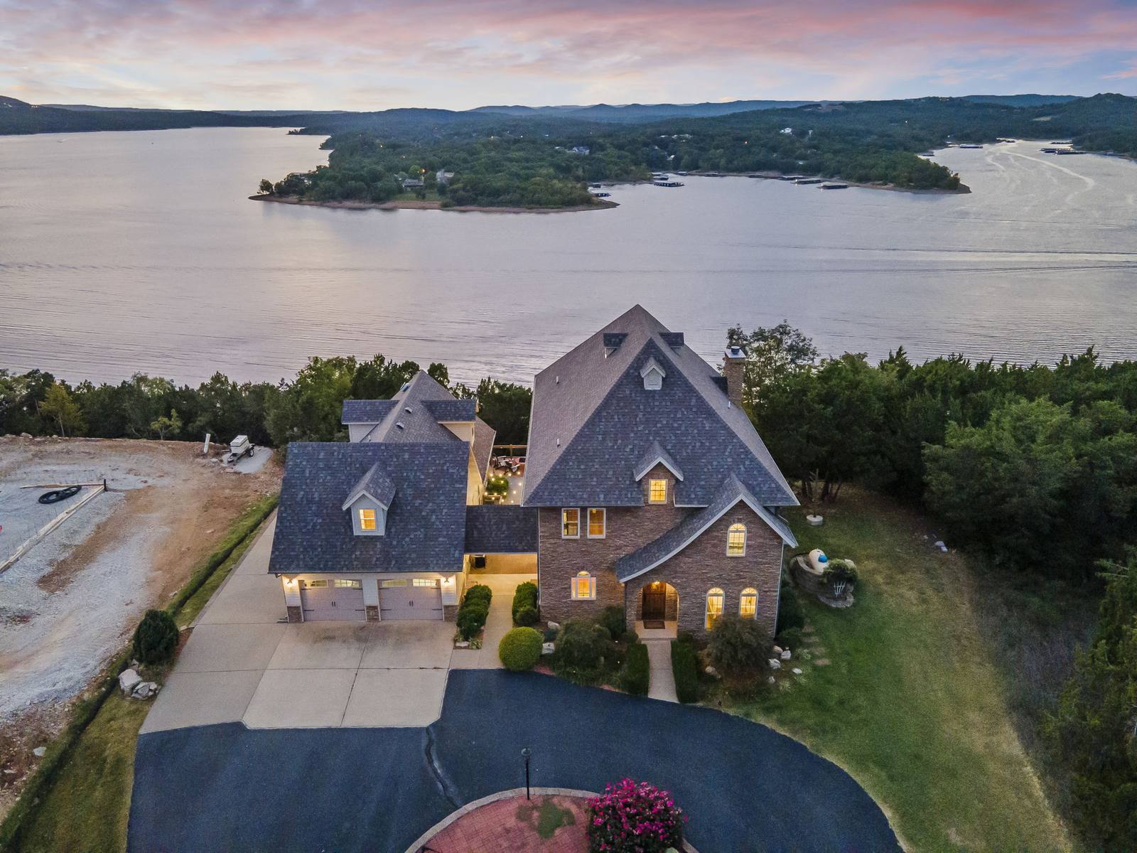 Drone view of a lakefront home at dusk